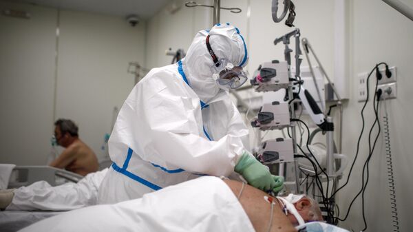 Медицинский работник и пациенты во временном госпитале для пациентов с COVID-19 в ледовом дворце Крылатское в Москве