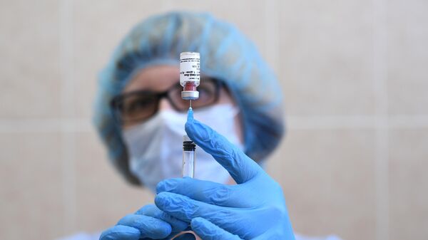 Медицинская сестра держит в руках вакцину Гам-Ковид-Вак в процедурном кабинете поликлиники Москвы