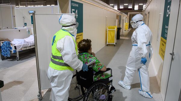Медицинские работники и пациент во временном госпитале для пациентов с COVID-19 в ледовом дворце Крылатское в Москве