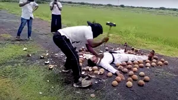 Стоп-кадр видео установления мирового рекорда по разбиванию кокосов кувалдой с завязанными глазами