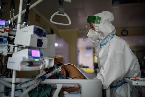 Медицинский работник оказывает помощь пациенту с COVID-19 в отделении реанимации и интенсивной терапии городской клинической больницы № 52