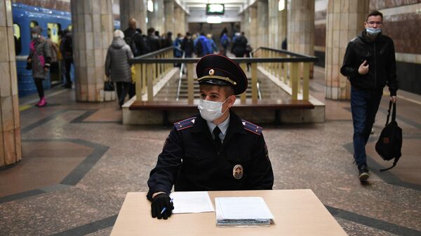 Сотрудник полиции в защитной маске на станции метро Красный проспект в Новосибирске