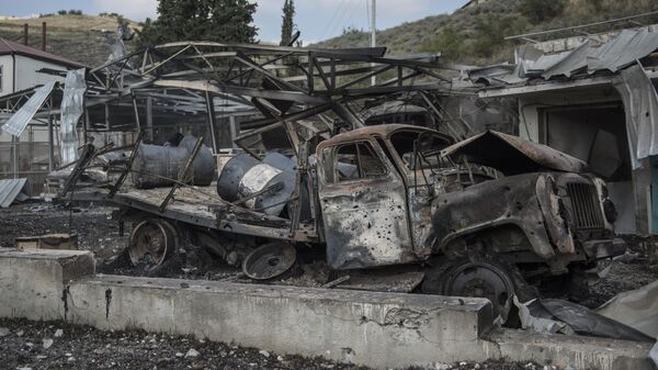 Сгоревшие автомобили у госпиталя в Мартакерте, разрушенного в результате обстрела