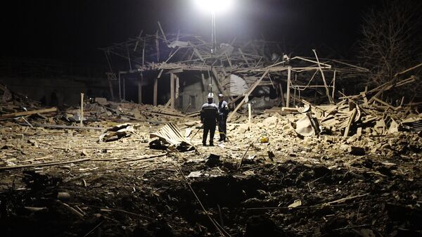 Сотрудники МЧС Азербайджана дежурят на месте разбора завалов разрушенных домов после ракетного обстрела города Гянджа