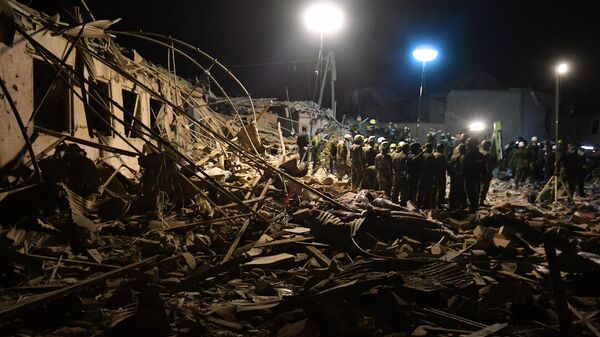 Сотрудники МЧС Азербайджана на месте разбора завалов разрушенных домов после ракетного обстрела города Гянджа