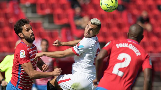 Granada's Spanish defender German Sanchez (L) and French defender Dimitri Foulquier (R) challenge Sevilla's Spanish midfielder Joan Jordan during the Spanish League football match between Granada and Sevilla at the Los Carmenes stadium in Granada on October 17, 2020. (Photo by JORGE GUERRERO / AFP)