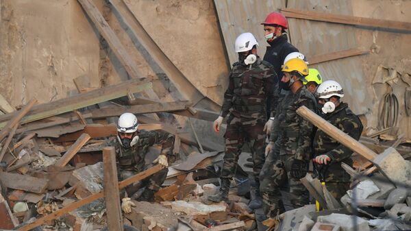 Сотрудники МЧС Азербайджана на месте разбора завалов разрушенных домов после ракетного обстрела города Гянджа