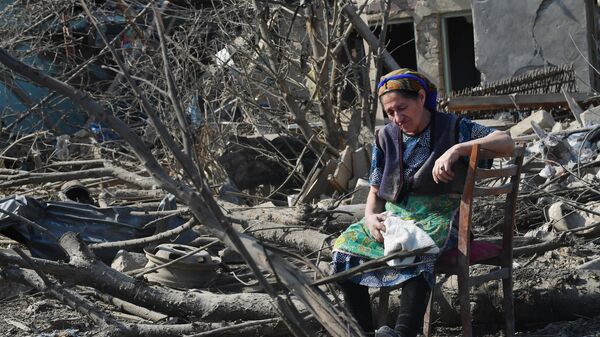 Жительница Гянджи у разрушенного после обстрела дома