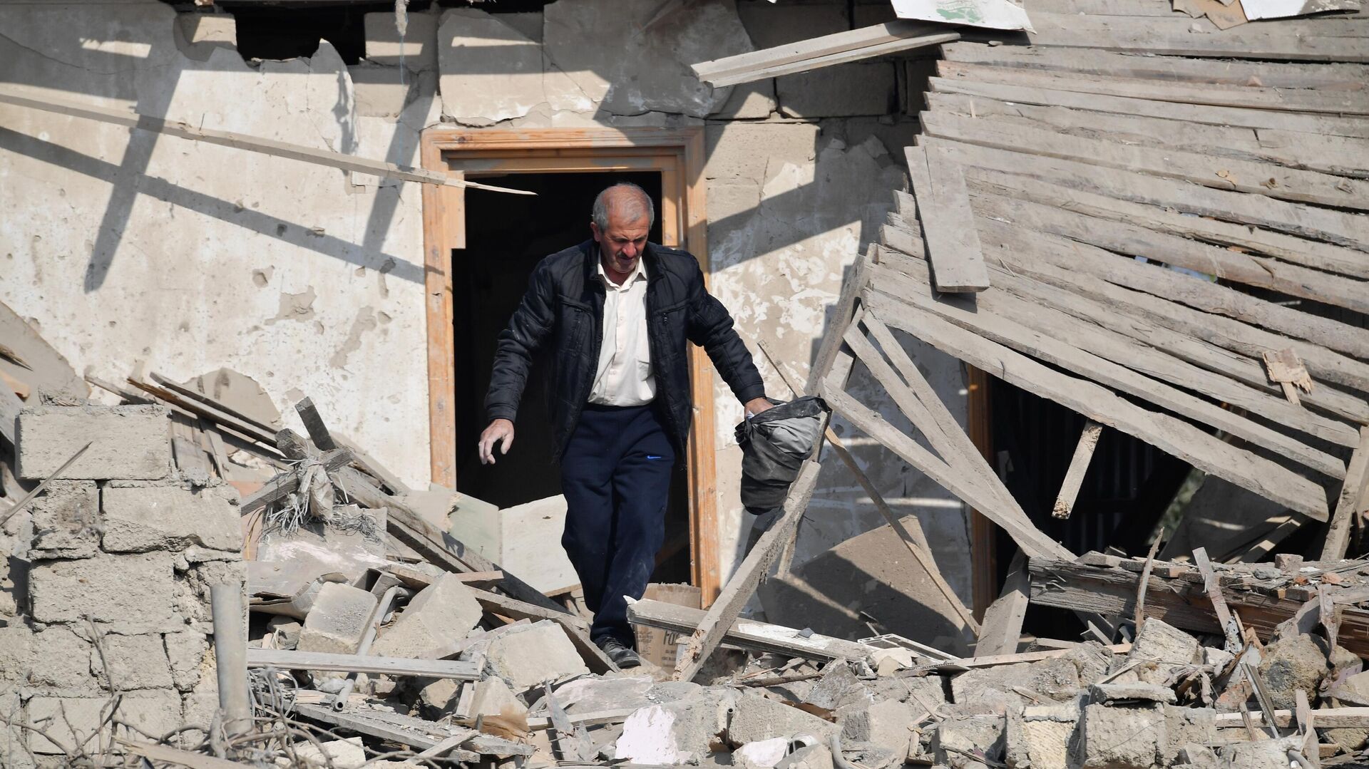 Житель Гянджи ищет свое имущество в разрушенном после обстрела доме - РИА Новости, 1920, 18.10.2020