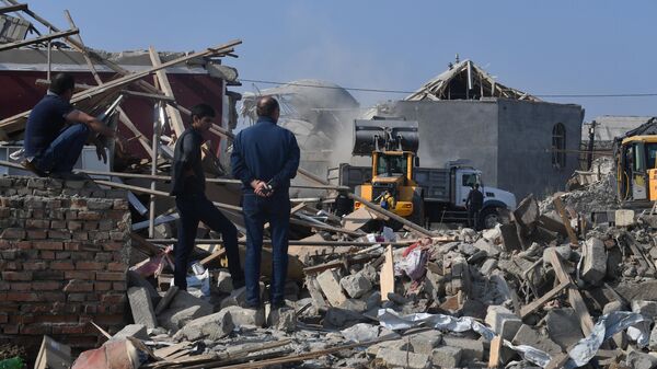 Разбор завалов на месте разрушенных после обстрела домов в Гяндже