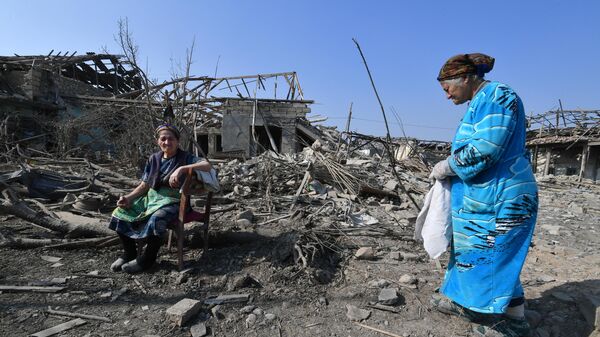 Жители Гянджи у разрушенных после обстрела домов