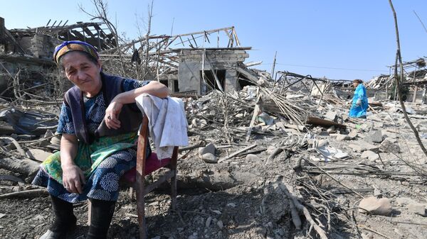 Жители Гянджи у разрушенных после обстрела домов