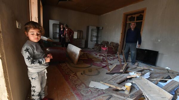 Жители Гянджи в разрушенном после обстрела доме