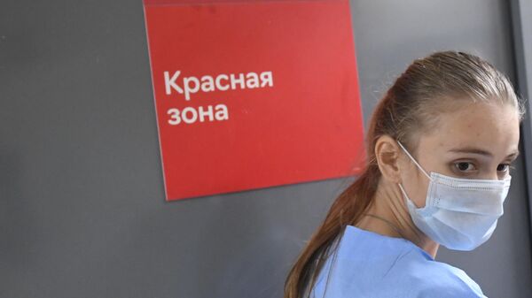 Медицинский работник у красной зоны во временном госпитале для пациентов с COVID-19 в автомобильном торговом центр Москва