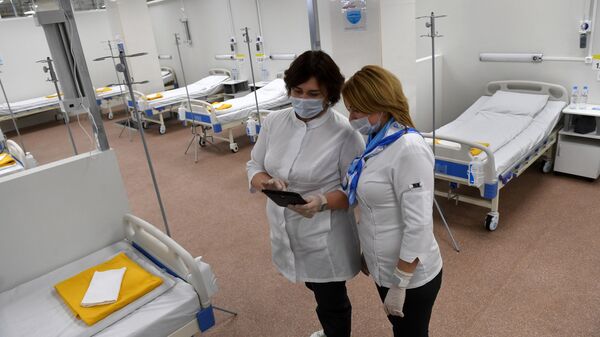 Медицинские работники во временном госпитале для пациентов с COVID-19, который открывается в автомобильном торговом центр Москва