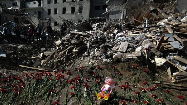 Цветы на месте гибели людей в результате обстрела города Гянджа