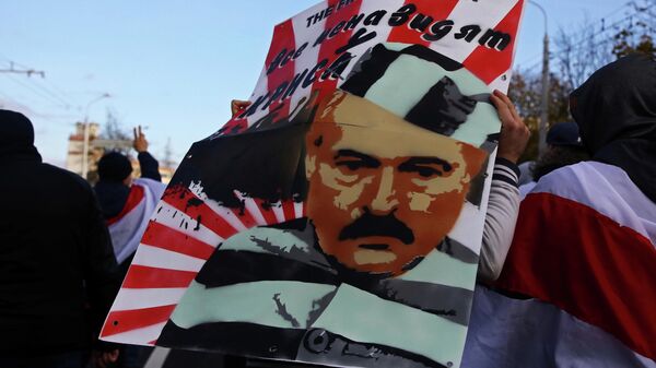 Демонстрант несет плакат с изображением президента Беларуси Александра Лукашенко во время митинга оппозиции в Минске
