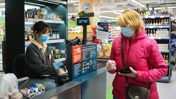 Покупатель оплачивает покупки на кассе в супермаркете