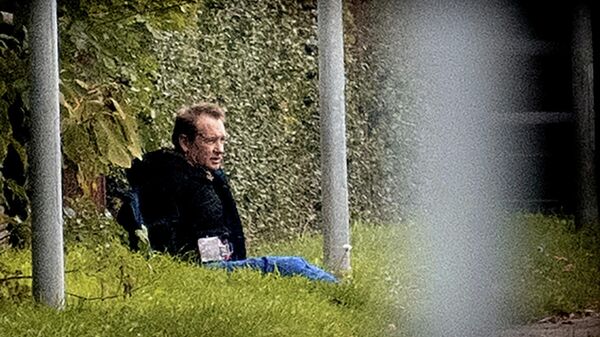 Предположительно Петер Мадсен сидит у забора в окружении полиции в Альбертслунде, Дания