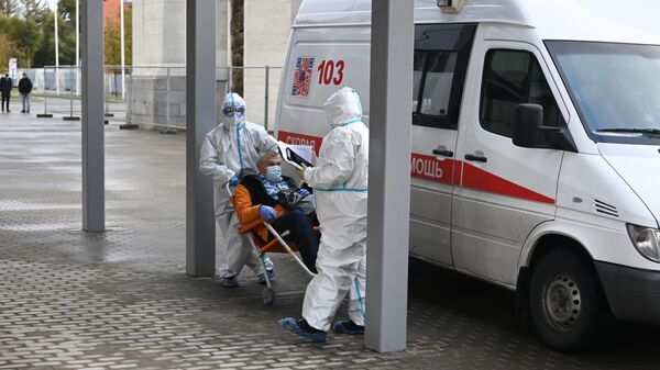 Сотрудники скорой помощи доставляют пациента во временный госпиталь COVID-19 на ВДНХ в Москве