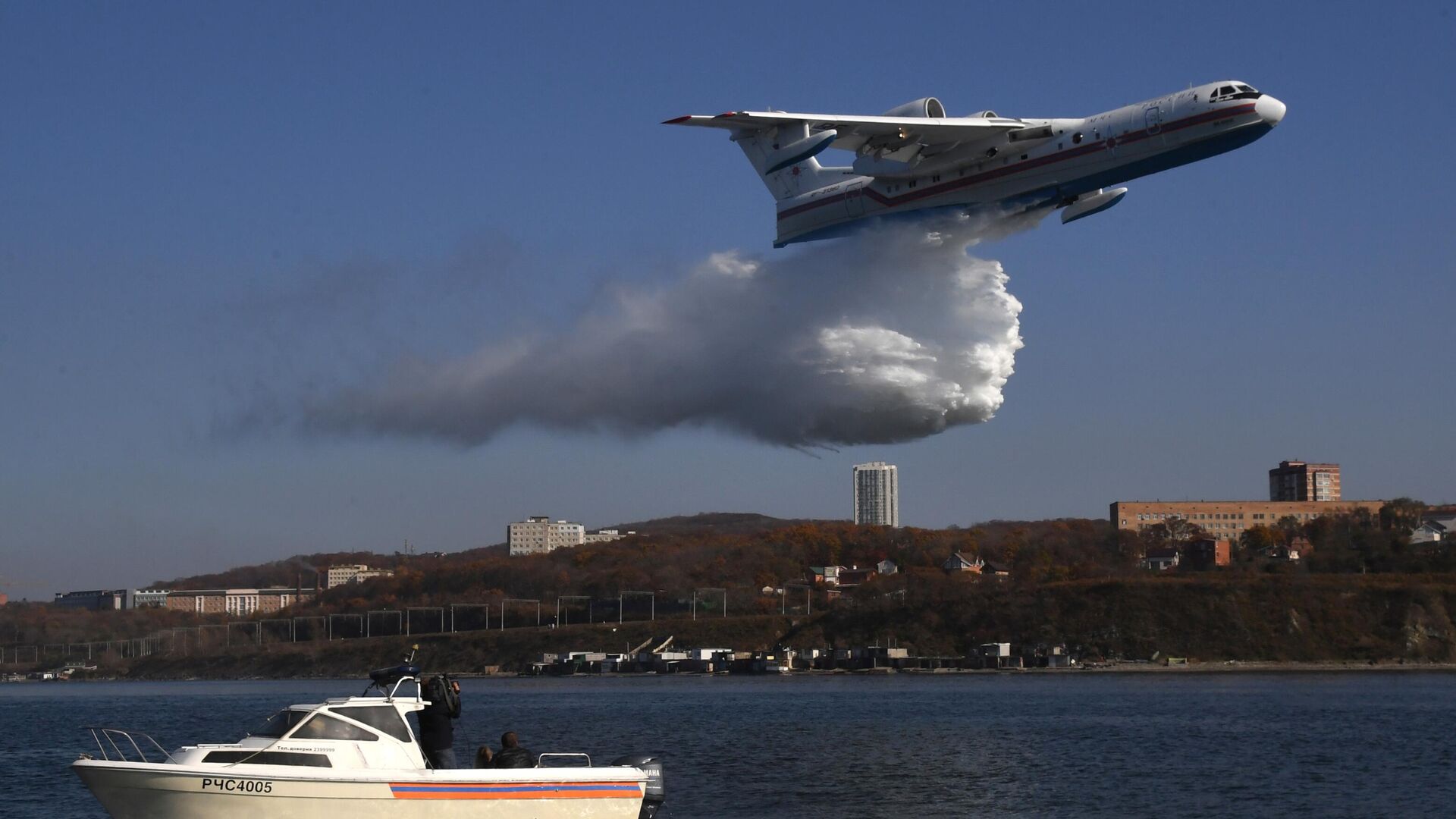 Многоцелевой самолет-амфибия Бе-200ЧС сбрасывает воду во время отработки взаимодействия авиации МЧС России с наземными и морскими спасательными службами в Приморье - РИА Новости, 1920, 08.07.2021