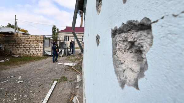 Жители поселка Сафарли в Агдамском районе Азербайджана у поврежденного после обстрела дома