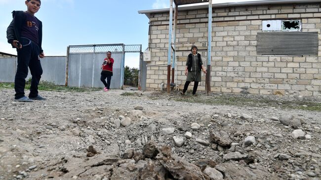 Жители поселка Сафарли в Агдамском районе Азербайджана у поврежденного после обстрела дома