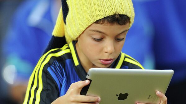 Ребенок с планшетом в руках во время футбольного матча