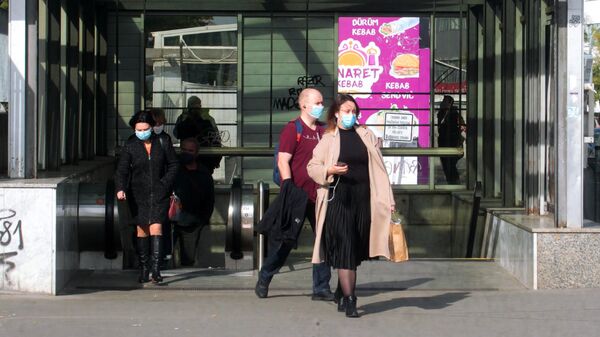 Прохожие в медицинских масках недалеко от торгового центра Аркады Панкрац в Праге