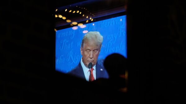 Экран с трансляцией финального раунда дебатов с участием президента США Дональда Трамп