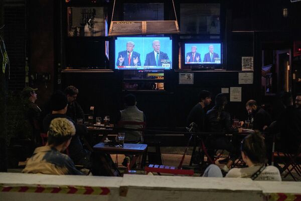 Жители Нью-Йорка смотрят трансляцию финального раунда дебатов с участием президента США Дональда Трампа и его соперника - кандидата в президенты США от Демократической партии Джо Байдена