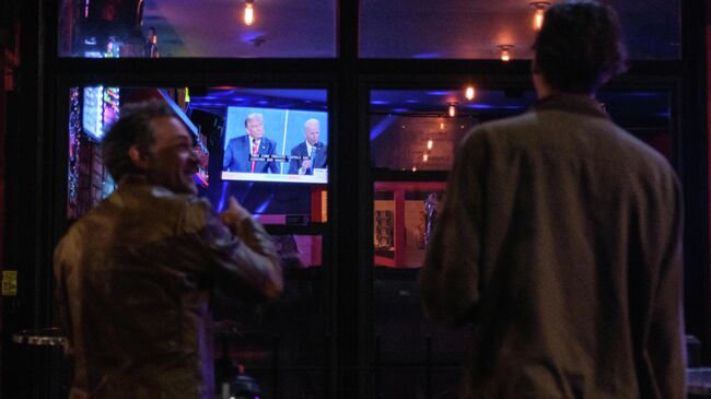 Жители Нью-Йорка смотрят трансляцию финального раунда дебатов с участием президента США Дональда Трампа и  Джо Байдена. Архив