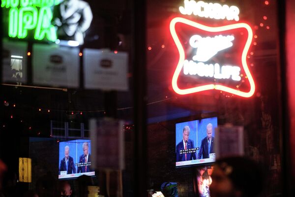Экран с трансляцией финального раунда дебатов с участием президента США Дональда Трампа и его соперника - кандидата в президенты США от Демократической партии Джо Байдена в одном из баров Нью-Йорка