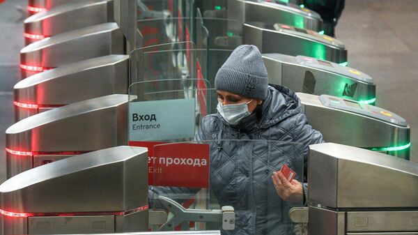 Женщина в защитной маске заходит на одну из станций Московского метрополитена