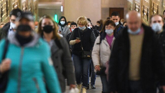 Пассажиры в защитных масках на одной из станций Московского метрополитена