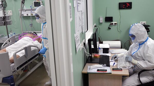 Медицинские работники и пациент в палате интенсивной терапии во временном госпитале COVID-19 на ВДНХ в Москве