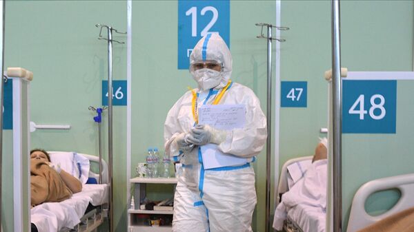 Медицинский работник и пациенты в палате временного госпиталя COVID-19 на ВДНХ в Москве