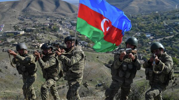Военнослужащие азербайджанской армии во время реконструкции водружения государственного флага на господствующей высоте у села Талыш