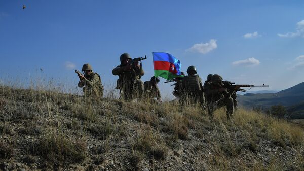 Военнослужащие азербайджанской армии во время реконструкции водружения государственного флага на господствующей высоте у села Талыш