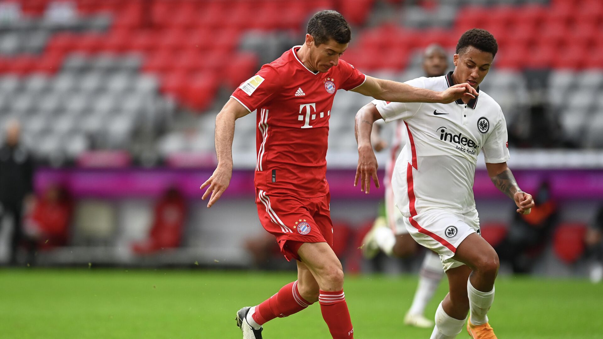 Bayern Munich's Polish forward Robert Lewandowski (L) scores the 3-0 goal for his hat-trick past Frankfurt's Brazilian defender Tuta during the German first division Bundesliga football match between FC Bayern Munich and Eintracht Frankfurt on October 24, 2020 in Munich, southern Germany. (Photo by CHRISTOF STACHE / various sources / AFP) / DFL REGULATIONS PROHIBIT ANY USE OF PHOTOGRAPHS AS IMAGE SEQUENCES AND/OR QUASI-VIDEO - РИА Новости, 1920, 24.10.2020