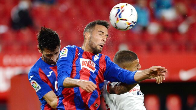 Eibar's Argentinian defender Esteban Burgos (C) jumps for the ball with Eibar's Portuguese defender Paulo Oliveira (L) and Sevilla's Brazilian defender Diego Carlos during the Spanish League football match between Sevilla and Eibar at the Sanchez Pizjuan stadium in Sevilla on October 24, 2020. (Photo by CRISTINA QUICLER / AFP)