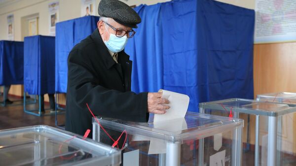  Мужчина голосует на одном из избирательных участков в Киеве