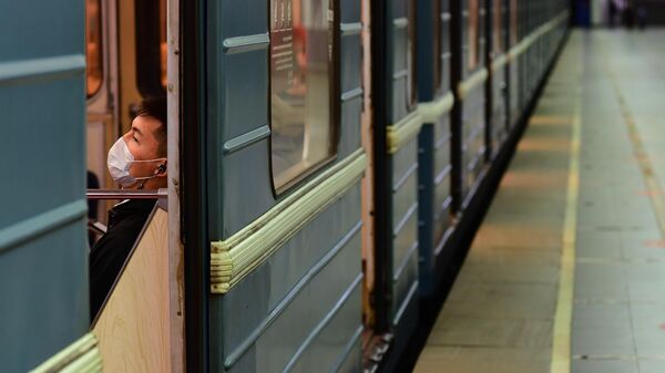 Пассажир в медицинской маске в вагоне поезда на станции метро Марьино Московского метрополитена