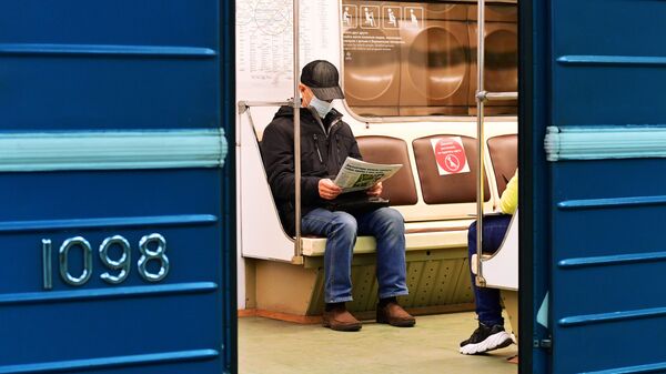 Пассажир в медицинской маске в вагоне поезда на станции метро Марьино Московского метрополитена