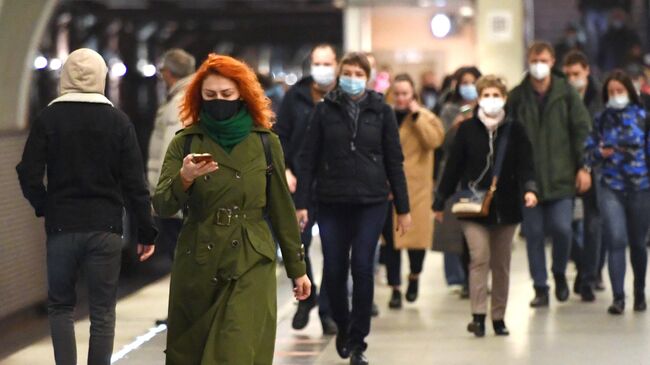 Люди в защитных масках на станции Московского метрополитена