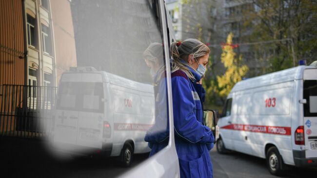 Медицинский работник у машины скорой помощи в Москве