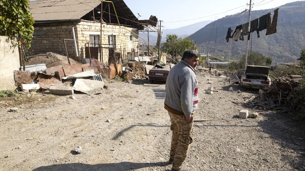 Мужчина возле своего дома, пострадавшего в результате обстрелов Степанакерта