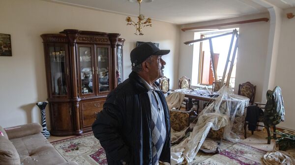 Мужчине в своем доме, пострадавшем в результате обстрела города Шуша