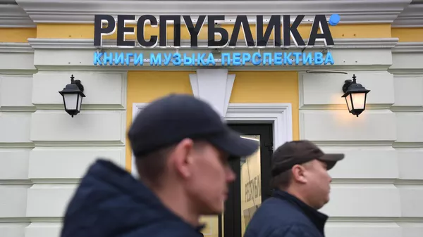Прохожие идут вдоль магазина Республика в Москве