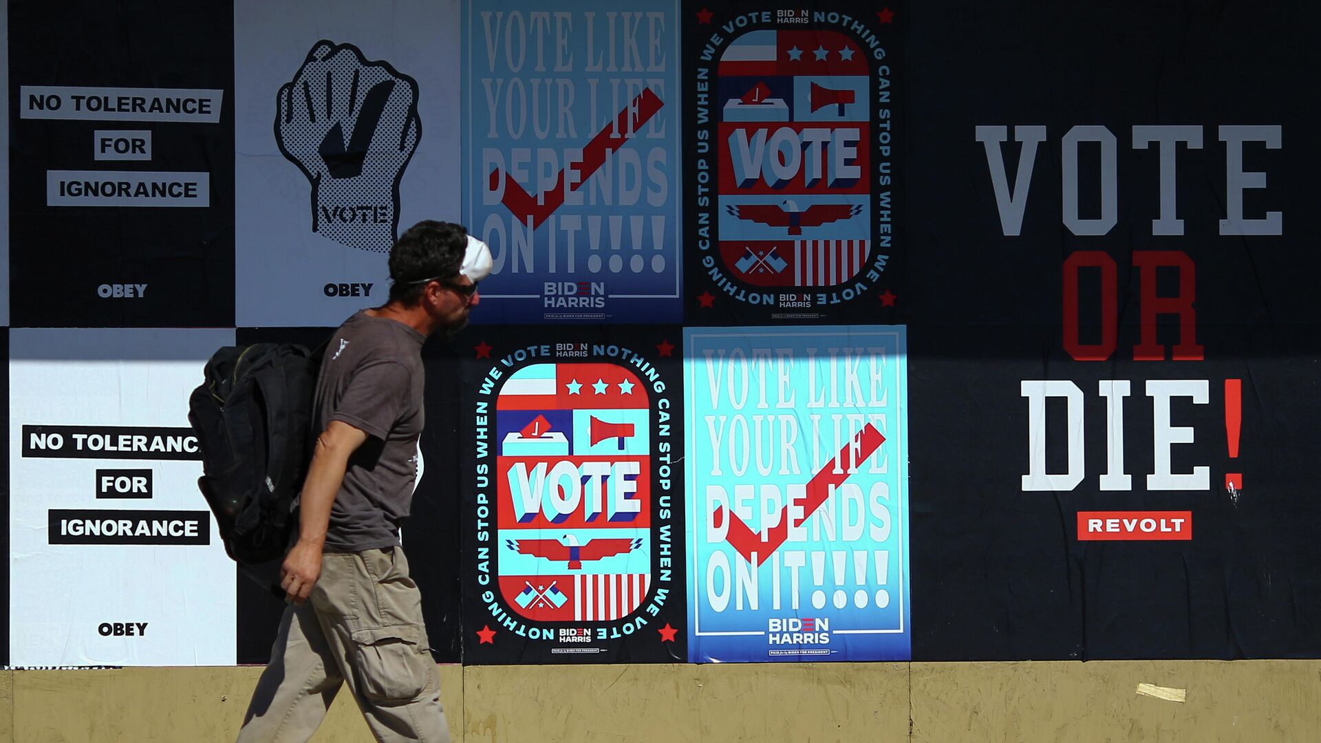 Мужчина проходит мимо предвыборных плакатов в городе Фениксе штата Аризона в США - РИА Новости, 1920, 03.11.2020